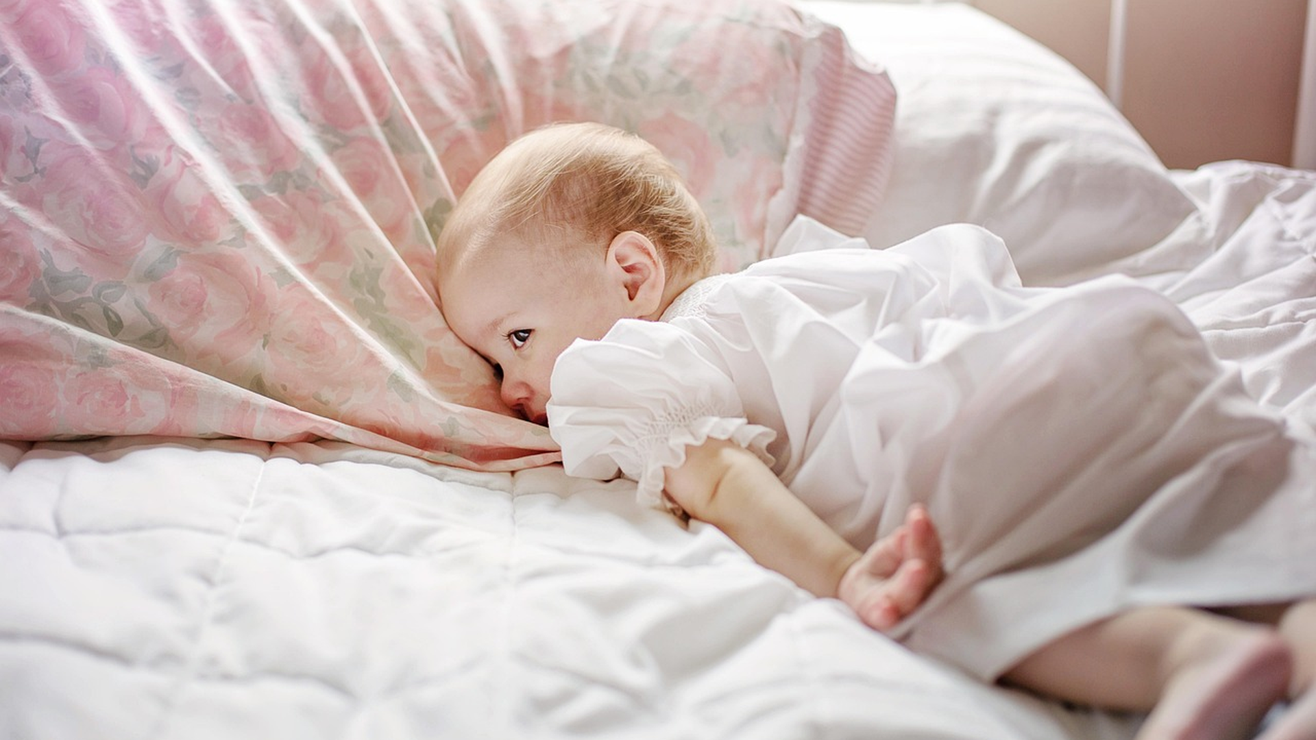 Child resting on a pillow with sheets, illustrating lice on bedding survival