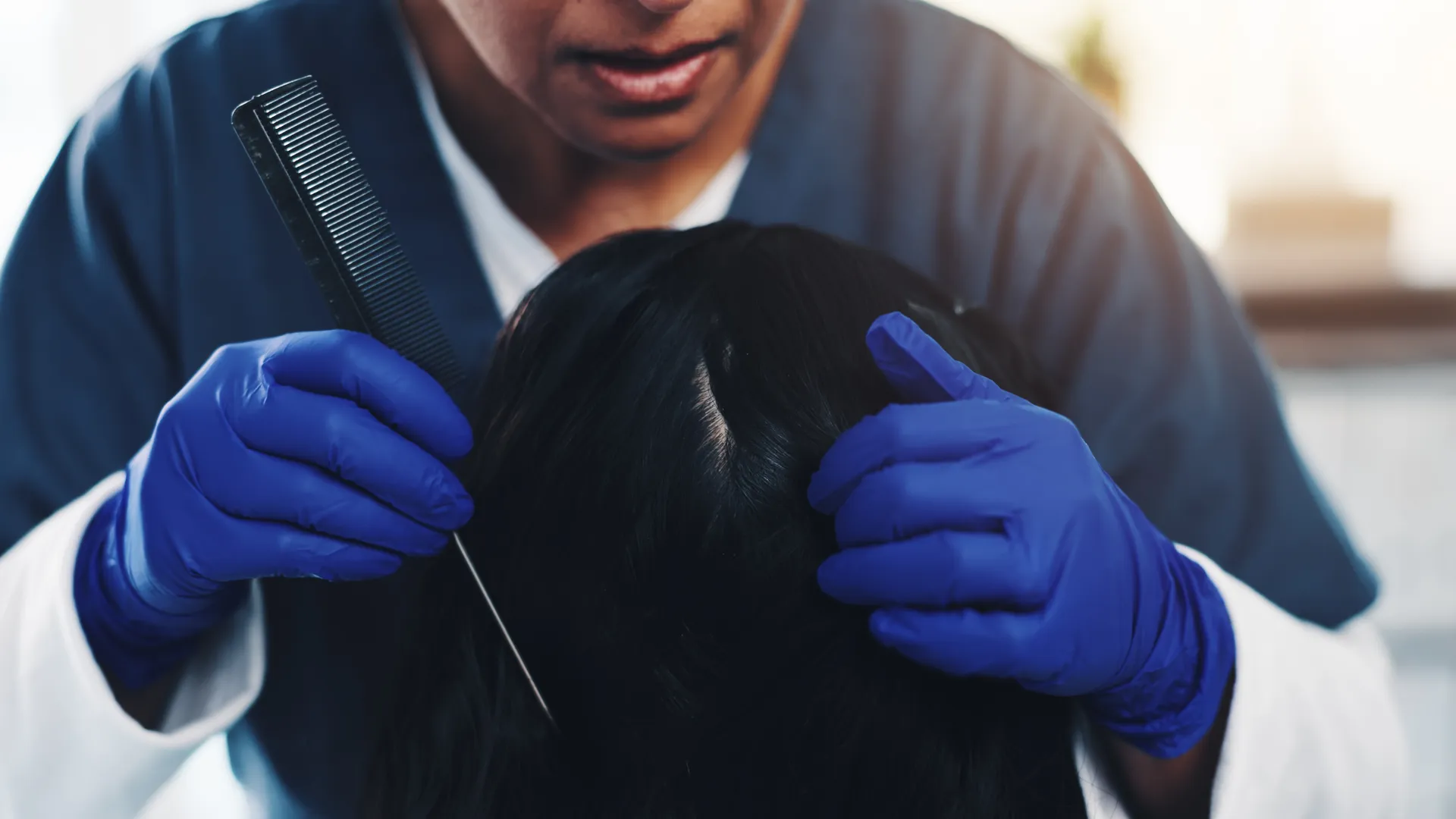 Professional examining a child's hair and scalp for head lice