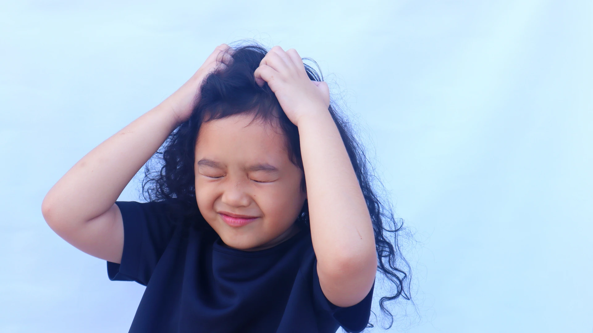 Child scratching her scalp after head lice treatment